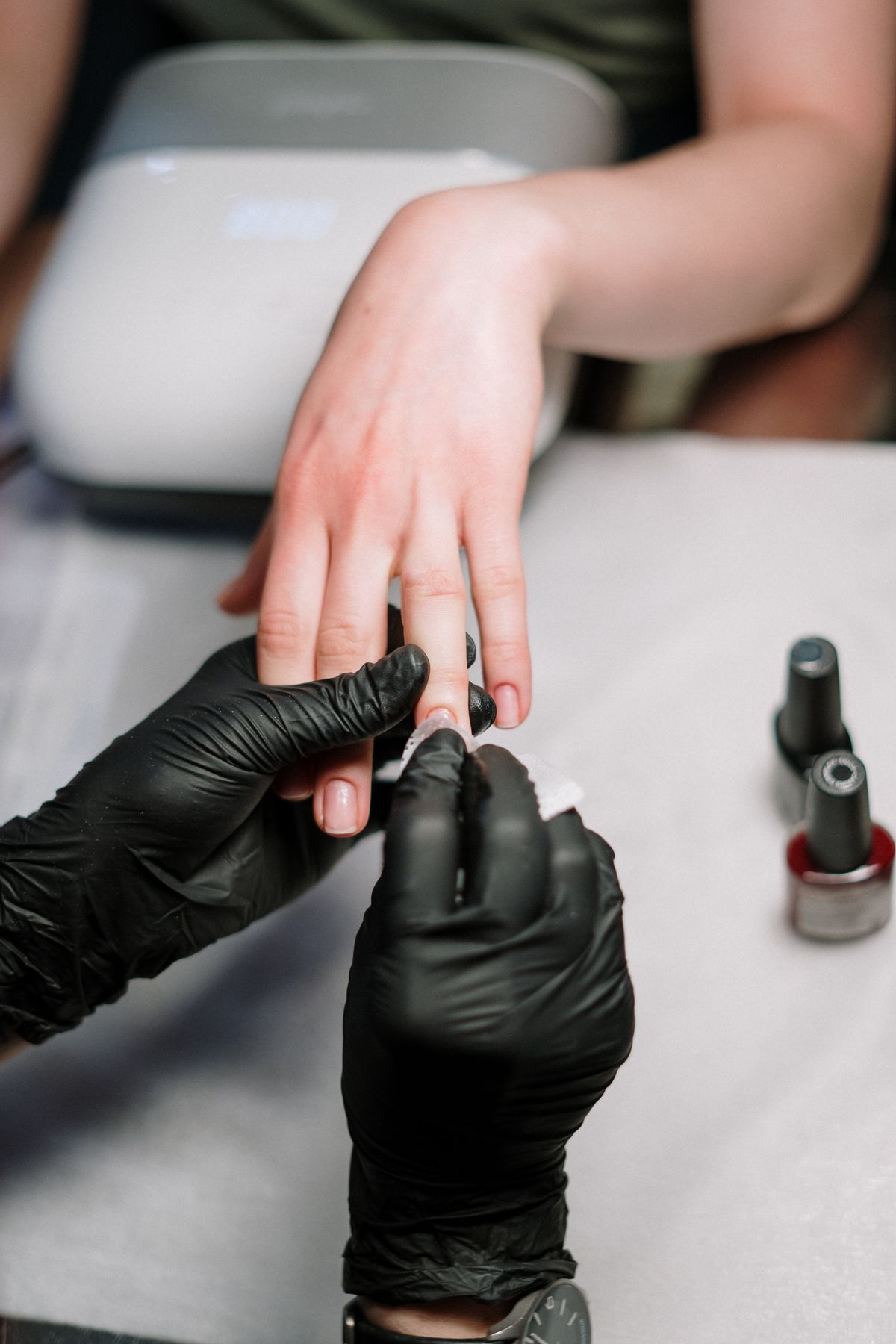 Manicurist finishing a nail set in private suite